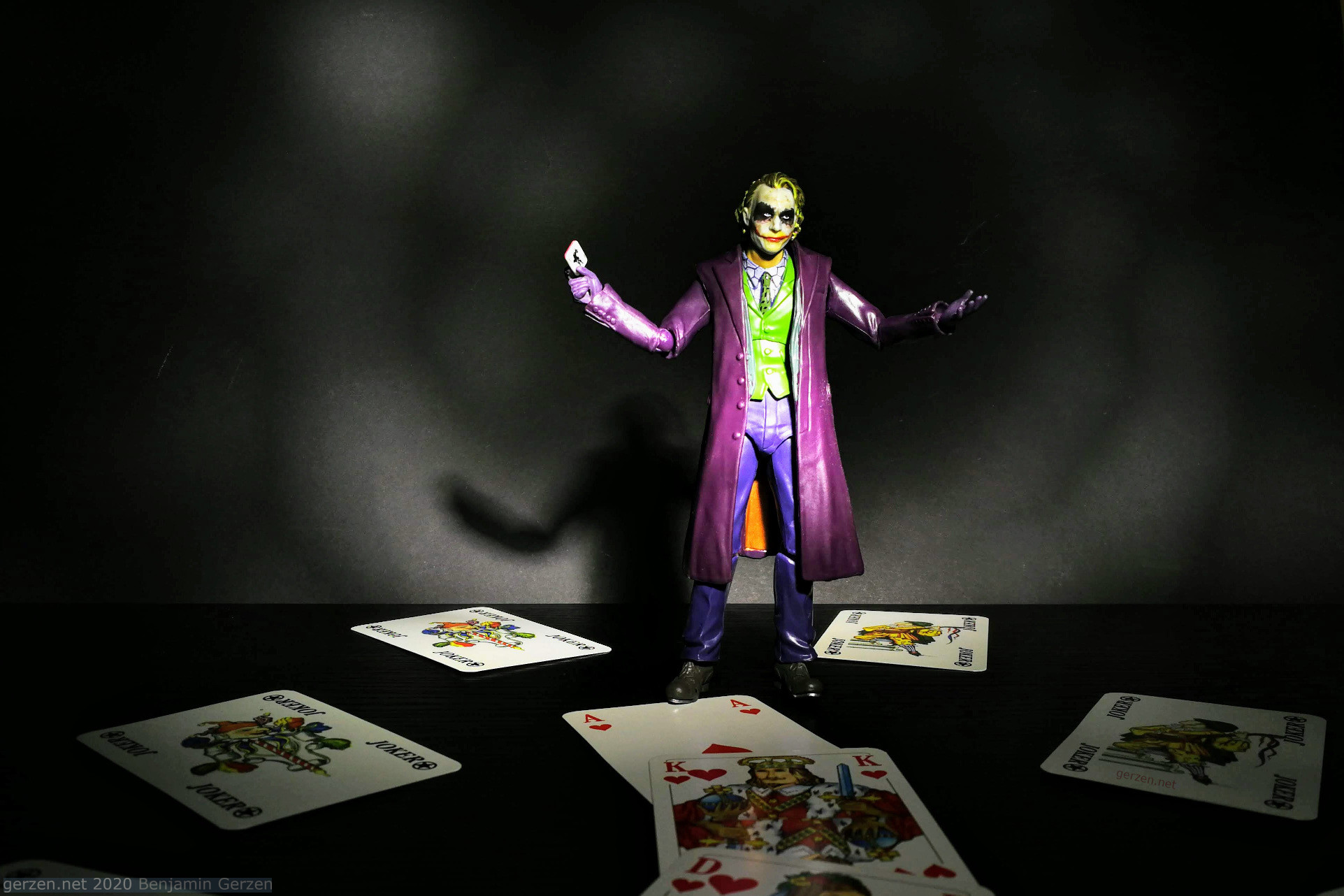 Фигурка Джокера с игральными картами на темном фоне